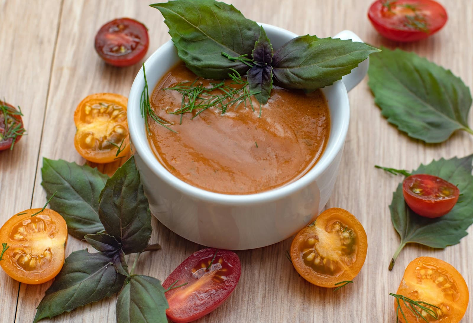 Photo of tomato soup with fresh herbs